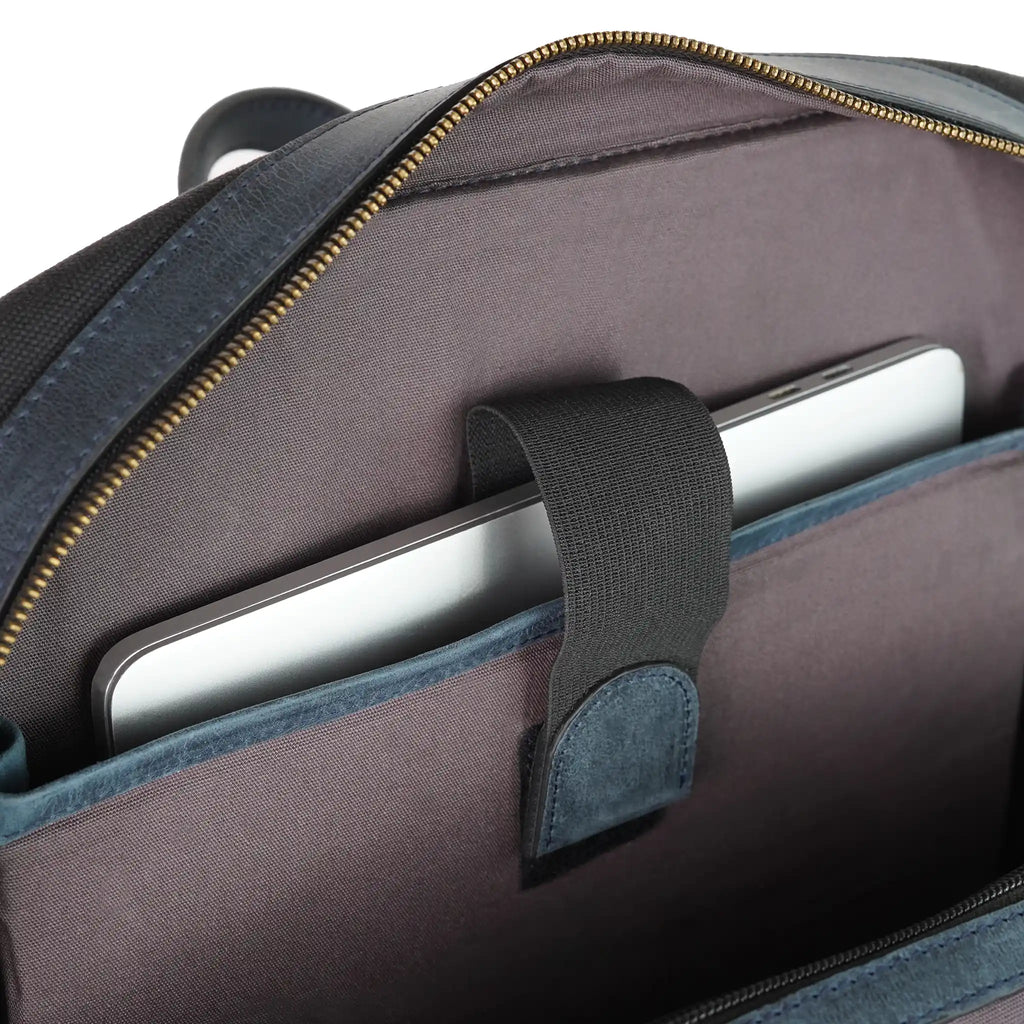 Open canvas backpack showing a silver laptop secured in a padded interior sleeve with a fastening strap from valanti.co.uk Backpack collection