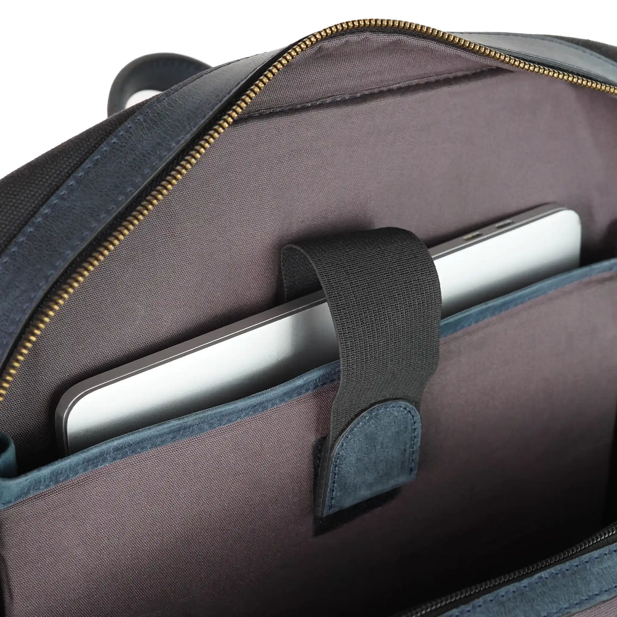 Open canvas backpack showing a silver laptop secured in a padded interior sleeve with a fastening strap from valanti.co.uk Backpack collection